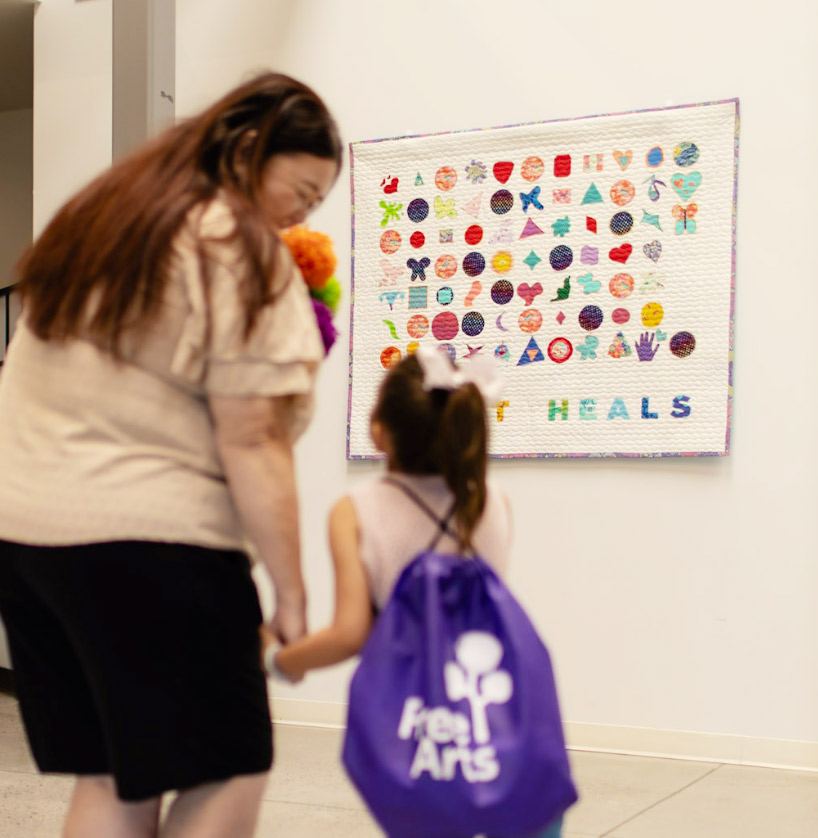 Mother and daughter looking at Art Heals quilt.